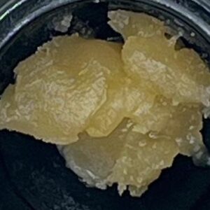 strawberry milk live resin extreme closeup, lookin greasy and glistening. smells like candy but when consumed has 3 transitioning flavor notes. first the candy strawberry, a middle creamy cake, finishes with a skunky limey hemp taste.